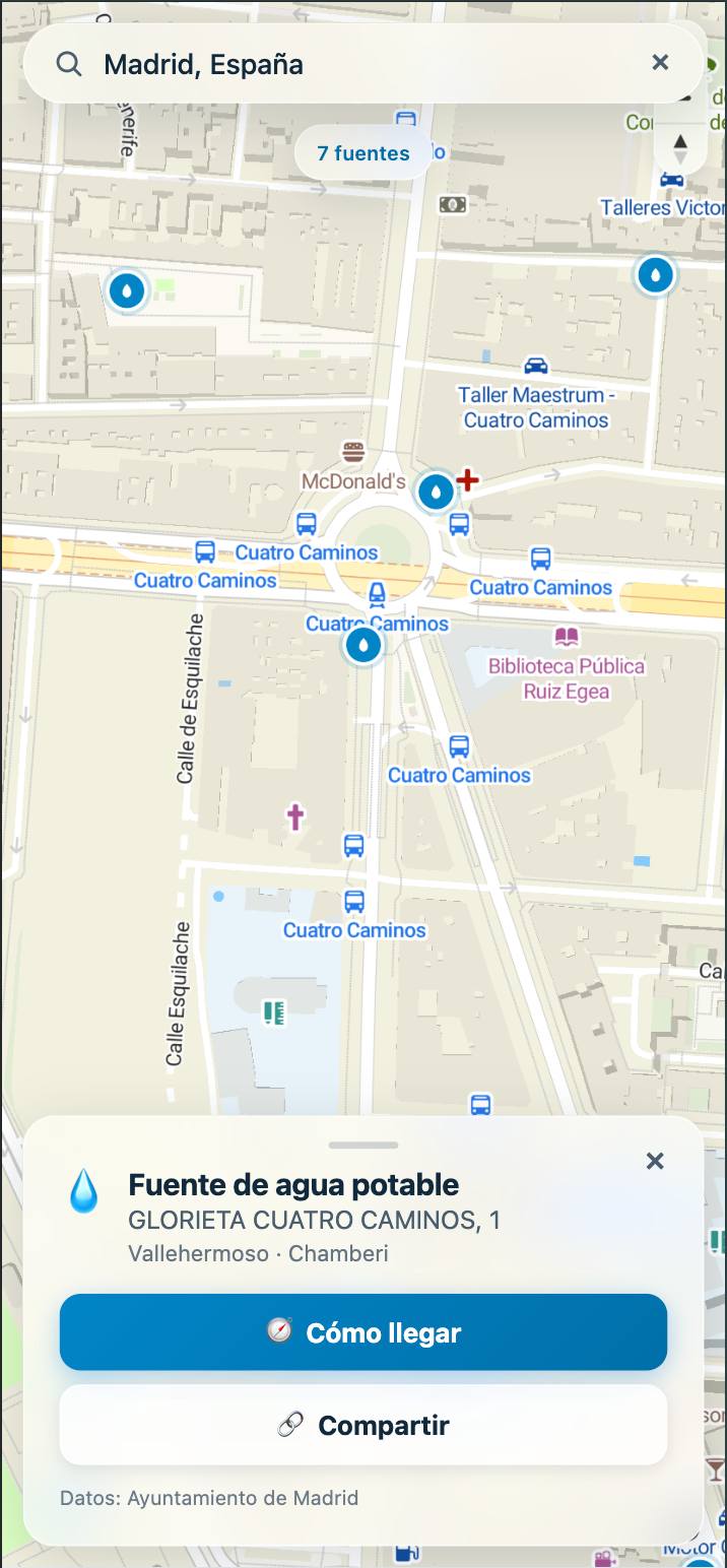 Captura de Fountly en móvil: mapa de Cuatro Caminos con marcadores de fuentes y el panel de una fuente en Glorieta Cuatro Caminos, 1, con botones de cómo llegar y compartir.